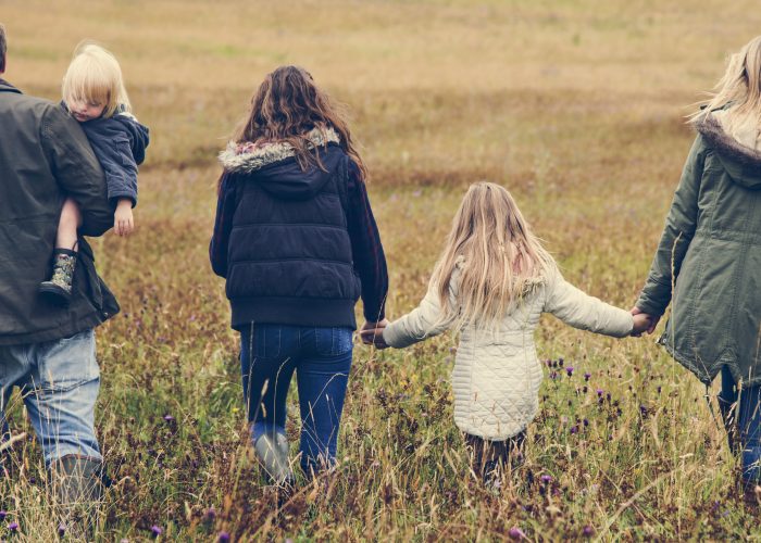 family walking through field family walking through field